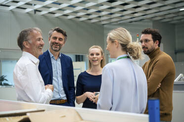 Glückliche Geschäftskollegen, die in der Industrie miteinander diskutieren - JOSEF14007