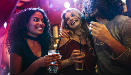 Glückliche junge Frauen feiern Freunde an der Bar. Gruppe von Freunden haben eine gute Zeit im Nachtclub. - JLPSF05002