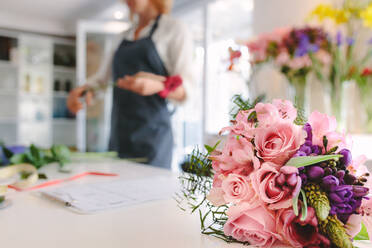 Schöne Blumenstrauß in Garten-Center mit Frau Florist arbeiten im Hintergrund. Fokus auf frischen Blumenstrauß. - JLPSF05055