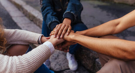 Unity and teamwork. Closeup image of young students making a stack of hands. - JLPSF05087