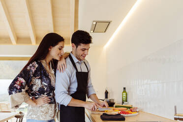 Side view of attractive couple cooking in a modern kitchen - ADSF39385