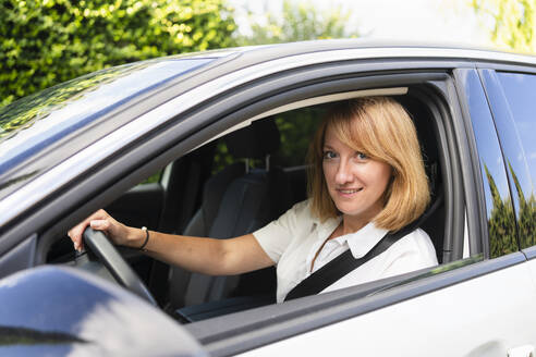 Lächelnde reife Frau fährt Auto - SVKF00641