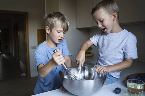 Brüder mischen Kuchenteig in der Küche zu Hause - NJAF00039