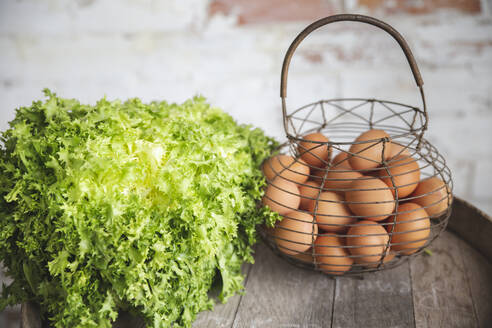 Eggs in basket by fresh green arugula - PCLF00159