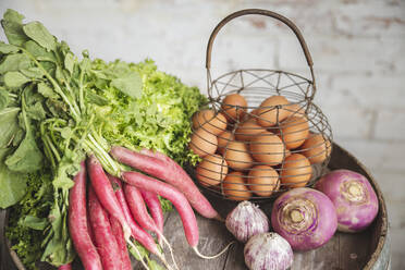 Eggs in basket with organic vegetables on barrel - PCLF00161