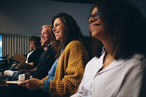 Eine Gruppe von Geschäftsleuten sitzt bei einem Seminar. Menschen sitzen im Publikum und lächeln während einer Tagung. - JLPSF05171