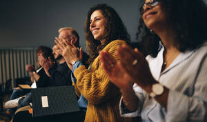 Geschäftsleute sitzen im Publikum und applaudieren. Eine Gruppe multiethnischer Geschäftsleute klatscht während einer Konferenz in die Hände. - JLPSF05173