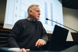 Geschäftsmann, der während eines Seminars eine Rede hält. Älterer männlicher Fachmann, der auf einem Gipfel eine Rede hält. - JLPSF05264