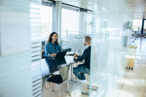 Smiling businesswoman taking interview with a man. Job interview in office boardroom. - JLPSF05306