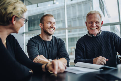 Geschäftsleute, die sich im Büro treffen. Ein Team von Fachleuten lächelt während einer Vertragsdiskussion im Sitzungssaal des Büros. - JLPSF05393