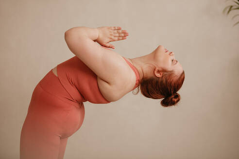 Starke Frau mit verbundenen Händen, die sich nach hinten beugt. Gesunde Frau macht Yoga-Übungen im Fitnessstudio. - JLPSF05783
