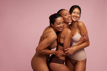 Three joyful women hugging, exuding confidence in their natural beauty in  underwear Stock Photo by Prostock-studio