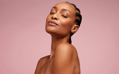 Close-up of a pretty female model with healthy skin on pink background. Woman having flawless skin and eyes closed. - JLPSF05835