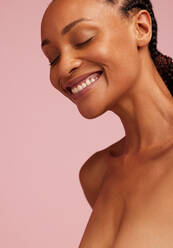 Portrait of a smiling african woman with healthy skin. African american female smiling with her eyes closed. - JLPSF05838