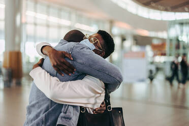 Tourist couple giving warm goodbye hug at airport departure gate. Wife getting good bye hug from her husband at airport. - JLPSF06018