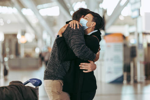 Frau empfängt Mann am Flughafen nach der Pandemie. Getrenntes Paar trifft sich am Flughafen nach der Pandemiesperrung. - JLPSF06050
