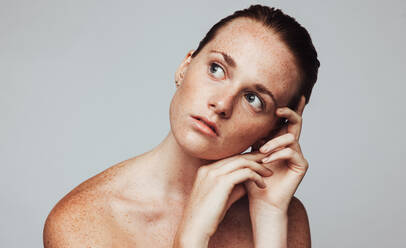 Young woman with freckles on body. Portrait of woman in deep thought looking away. - JLPSF06121