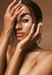 Nahaufnahme einer jungen Frau mit Vitiligo, die ihr Gesicht mit der Hand bedeckt. Modebild einer schönen Frau mit Vitiligo - JLPSF06173