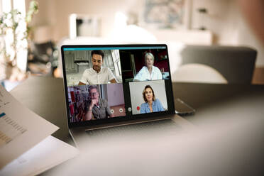 Business people having online meeting. Group of men and woman having a video conference over a laptop. - JLPSF06298