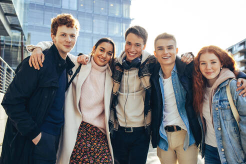 Porträt von glücklichen jungen Leuten, die in der Universität stehen. College-Freunde stehen zusammen und posieren im Freien. - JLPSF06322