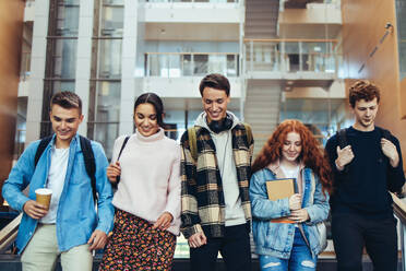 Junge Studenten auf dem Weg zum Unterricht. Gruppe junger Leute, die gemeinsam auf dem College-Campus spazieren gehen. - JLPSF06324