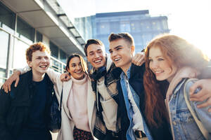 Junge Leute, die in der Universität zusammenstehen. Studenten, die gemeinsam ihre Freizeit an der Hochschule im Freien verbringen. - JLPSF06350