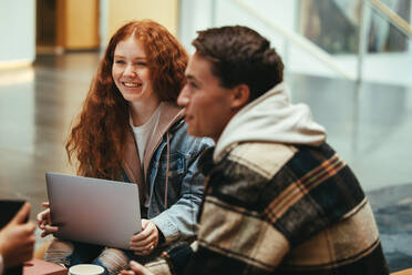 Freunde, die gemeinsam an der Universität studieren. Studenten, die zusammensitzen und in der Gruppe über bestimmte Themen diskutieren. - JLPSF06353