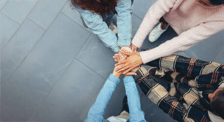 Top view of student putting their hands on top of each other. Young people making a stack of hands with copy space. - JLPSF06354