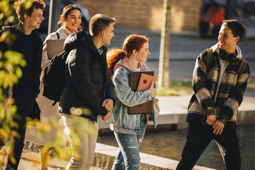 College-Studenten, die sich nach dem Unterricht im Freien amüsieren. Junge Leute, die nach dem Unterricht nach draußen gehen. - JLPSF06367