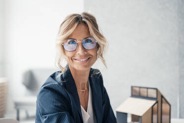 Smiling real estate agent wearing eyeglasses at office - JOSEF14103