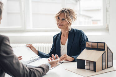 Immobilienmakler mit Vertrag vor einem Kunden im Büro - JOSEF14118