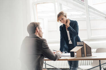 Businesswoman doing paperwork with customer at office - JOSEF14130