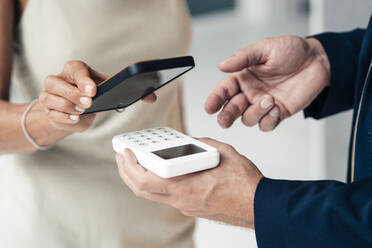 Verkäufer mit Kreditkartenleser in der Hand und zahlender Frau - JOSEF14159