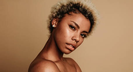 Portrait of african american woman on brown background. Cropped shot of curly haired woman. - JLPSF06370