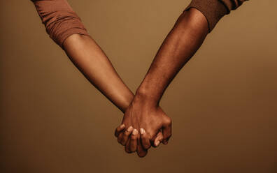 Abgeschnittene Aufnahme eines Paares, das sich an der Hand hält und die Finger ineinander verschränkt. Zwei Menschen, die sich an der Hand halten, stehen nebeneinander. - JLPSF06402
