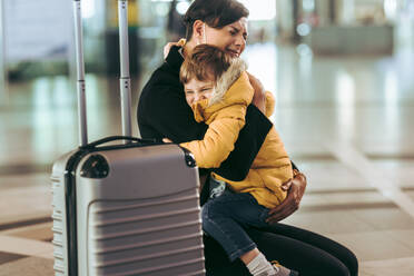 Eine Mutter wird emotional, während sie ihr Kind am Flughafen umarmt. Eine Frau, die von einer Reise kommt, trifft ihren Sohn und weint. - JLPSF06606