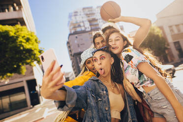 Verrückte Selfies mit Freunden. Eine Gruppe von Freunden der Generation Z posiert für ein Selfie, während sie zusammen in der Stadt abhängen. Multiethnische junge Menschen, die ihre lustigen Momente festhalten. - JLPSF06792