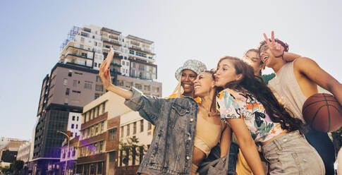 Eine Gruppe multiethnischer junger Menschen posiert für ein gemeinsames Selfie im Freien. Fröhliche Freunde der Generation Z haben Spaß und halten ihre glücklichen Momente in der Stadt fest. - JLPSF06798