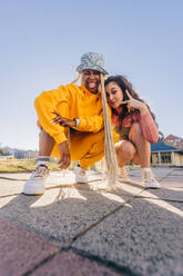 Young female friends posing for the camera. Two female best friends friends having fun together outdoors in the city. Happy female youngsters feeling vibrant and full of life. - JLPSF06861