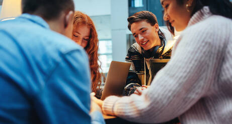 College students working on project in library. Friends doing group studies in college. - JLPSF06986