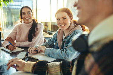 Fröhliche Gruppe von Studenten in einer Diskussion in der High School. Junge Menschen lächelnd während des Studiums in College-Campus. - JLPSF07038