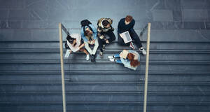 Junge Leute auf dem College in der Pause. Jungen und Mädchen sitzen auf einer Treppe auf dem Universitätscampus. - JLPSF07071
