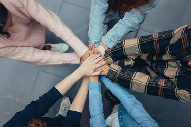 Hands stacking in college by friends. Young People putting hands together. - JLPSF07079