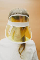 Woman staring through yellow transparent sun visor - SVCF00181