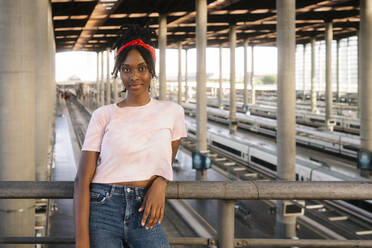 Confident woman wearing bandana at railroad station - MMPF00362