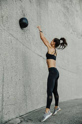 Female athlete exercising with a medicine ball. Woman in fitness wear doing workout using a medicine ball. - JLPSF07376