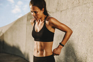 Healthy woman relaxing after workout. Female taking a breather from workout. - JLPSF07381