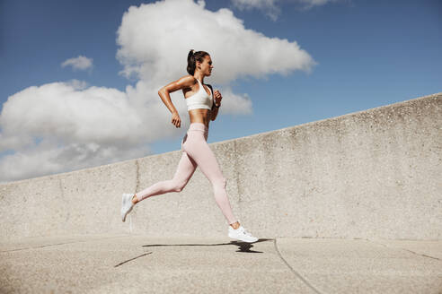 Woman in sportswear running. Woman runner in jogging outfit running outdoors. - JLPSF07457