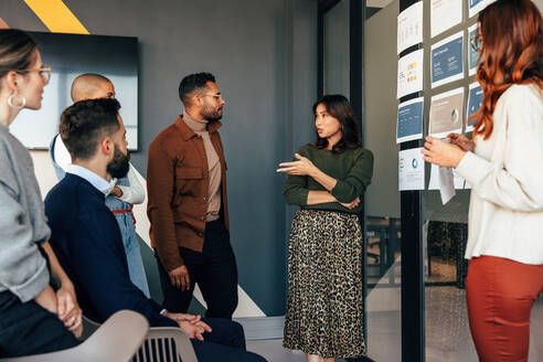 Weibliche Führungskraft bei einer Diskussion mit ihrem Geschäftsteam. Gruppe multikultureller Geschäftsleute bei einer Besprechung in einem modernen Büro. Unterschiedliche Unternehmer, die als Team zusammenarbeiten. - JLPSF07527