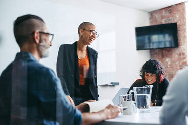 Geschäftsleute, die während einer Besprechung in einem Büro lachen. Eine Gruppe erfolgreicher Geschäftsleute bei ihrer morgendlichen Besprechung an einem modernen Arbeitsplatz. Kreative Geschäftsleute, die zusammenarbeiten. - JLPSF07639